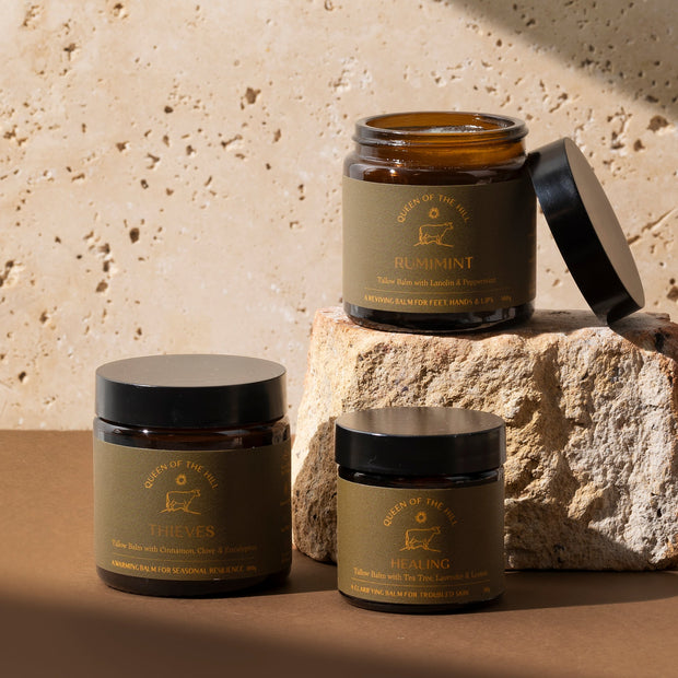 Three jars with labels on a textured stone surface